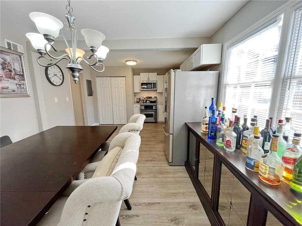 6520 Roswell Road, Unit 3 Atlanta, GA 30328 - Photo 19 of 47 a living room with dining table furniture a chandelier a large window