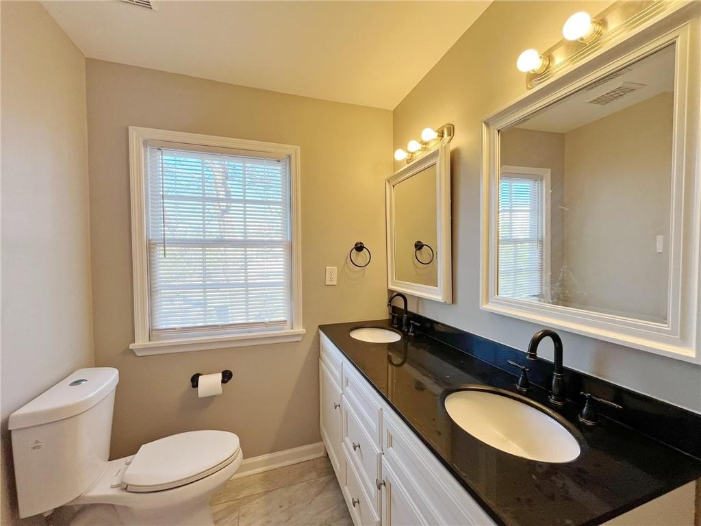 6520 Roswell Road, Unit 3 Atlanta, GA 30328 - Photo 28 of 47 a bathroom with a granite countertop double vanity sink a mirror and a toilet
