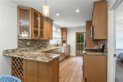 a kitchen with kitchen island granite countertop a sink a counter top space stainless steel appliances and cabinets