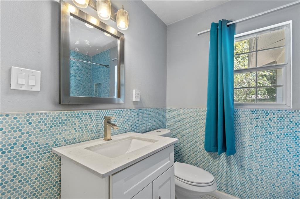 2105 Fortview Road Austin, TX 78704 - Photo 27 of 37 A fresh bathroom presents a crisp vanity and a shower with blue mosaic tile accents.