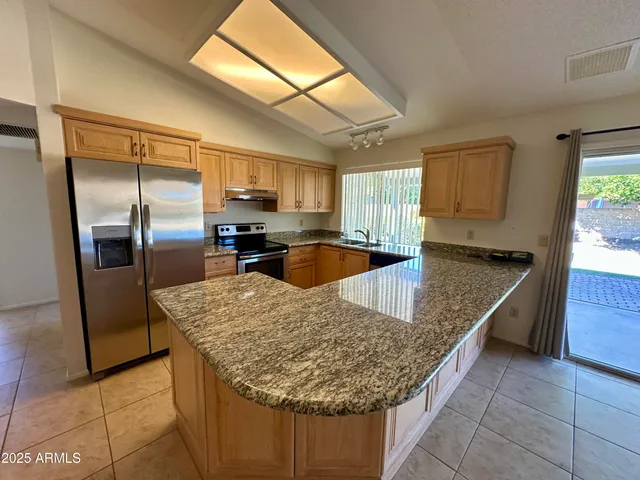 a kitchen with stainless steel appliances granite countertop a sink stove and refrigerator