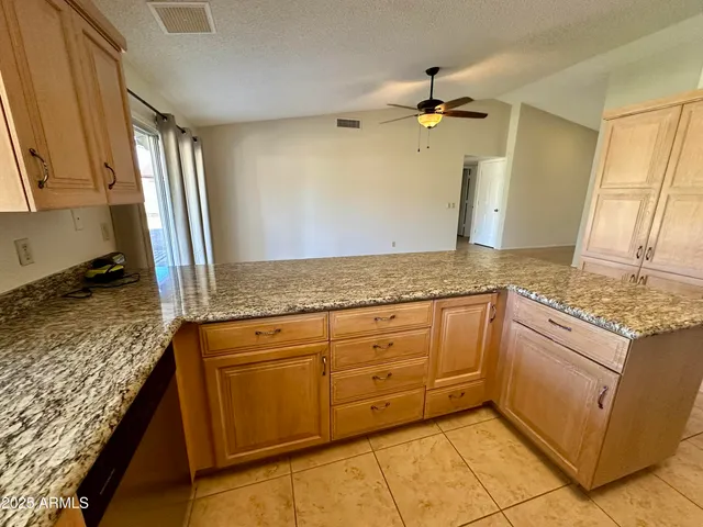 a kitchen with granite countertop cabinets stainless steel appliances a sink and a counter top space