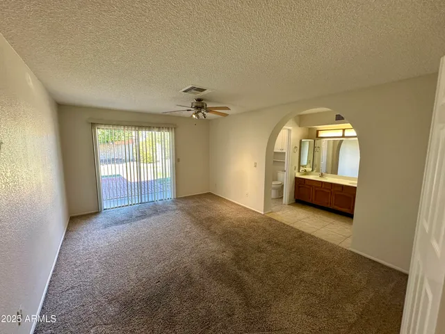 an empty room with a window and chandelier