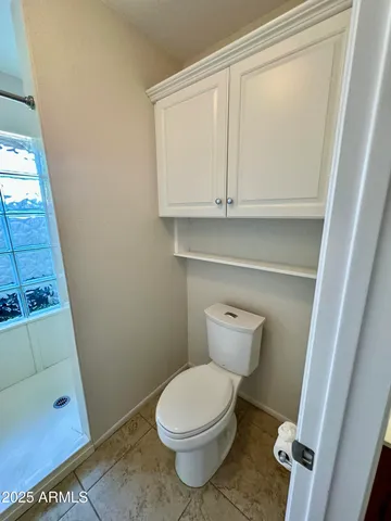 a bathroom with a toilet and a shower