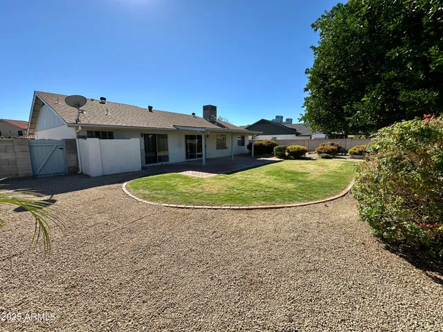 a view of a house with a yard and large tree