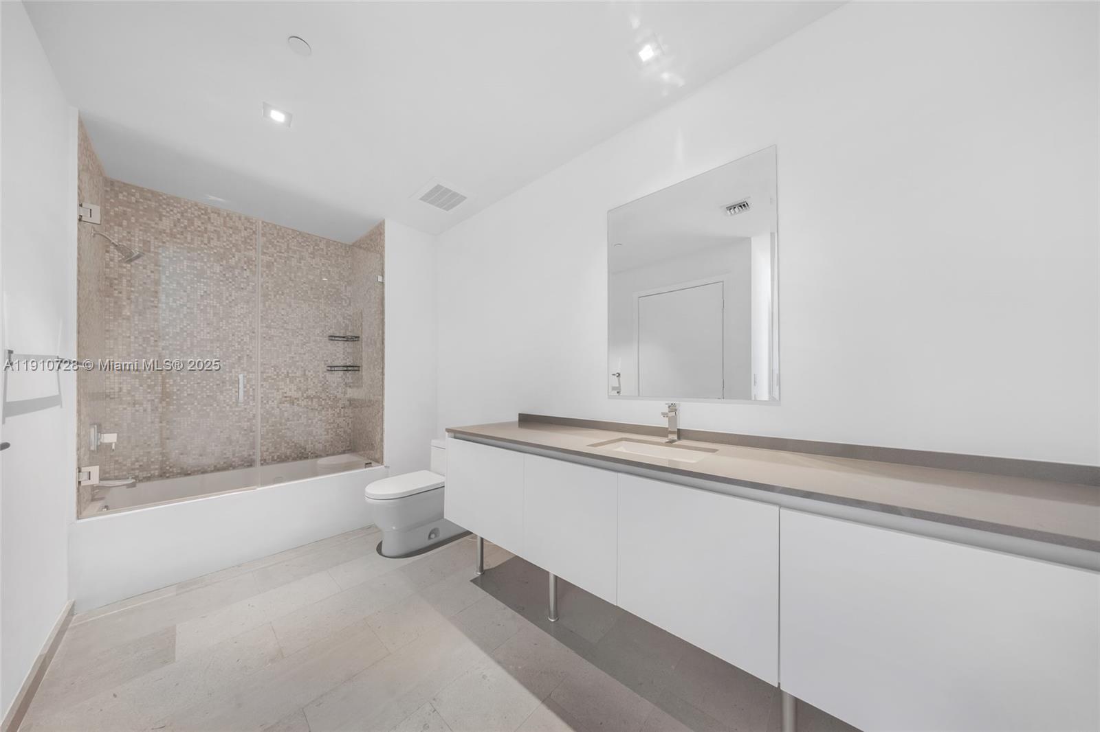 88 Southwest 7th Street, Unit 1004 Miami, FL 33130 - Photo 28 of 40 a bathroom with a granite countertop sink a toilet and a bathtub