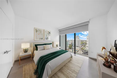 a bedroom with a bed and a large window