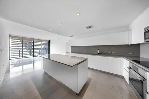 a kitchen with stainless steel appliances granite countertop a stove a sink and a white cabinets