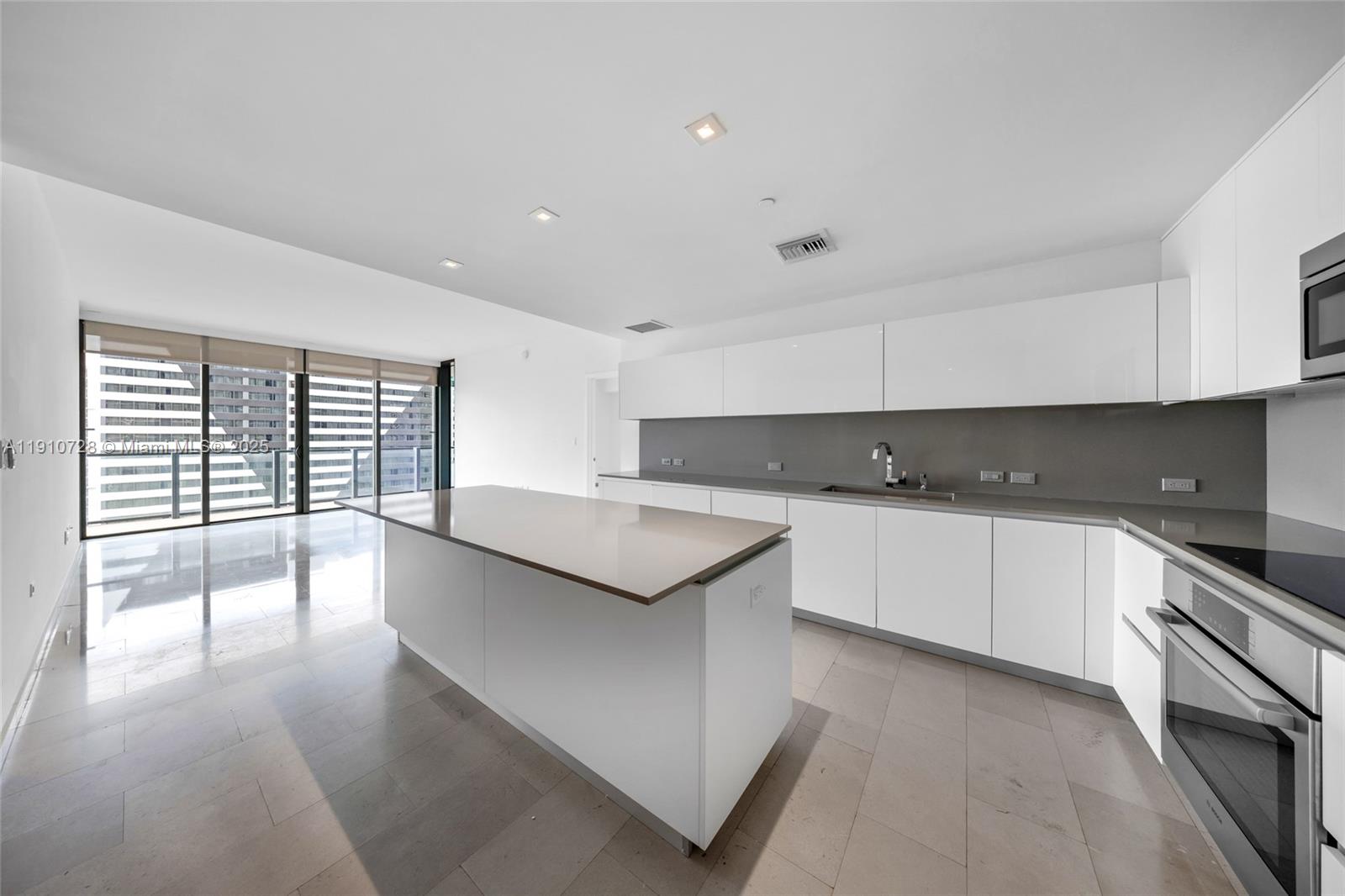 88 Southwest 7th Street, Unit 1004 Miami, FL 33130 - Photo 8 of 40 a kitchen with stainless steel appliances granite countertop a stove a sink and a white cabinets