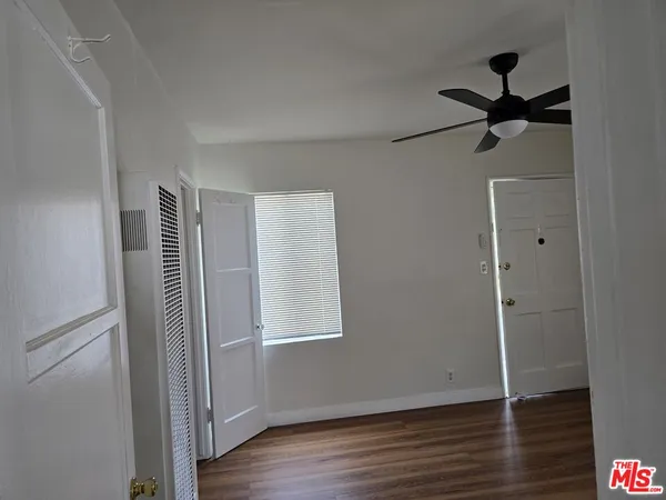 a view of a livingroom with wooden floor and a ceiling fan