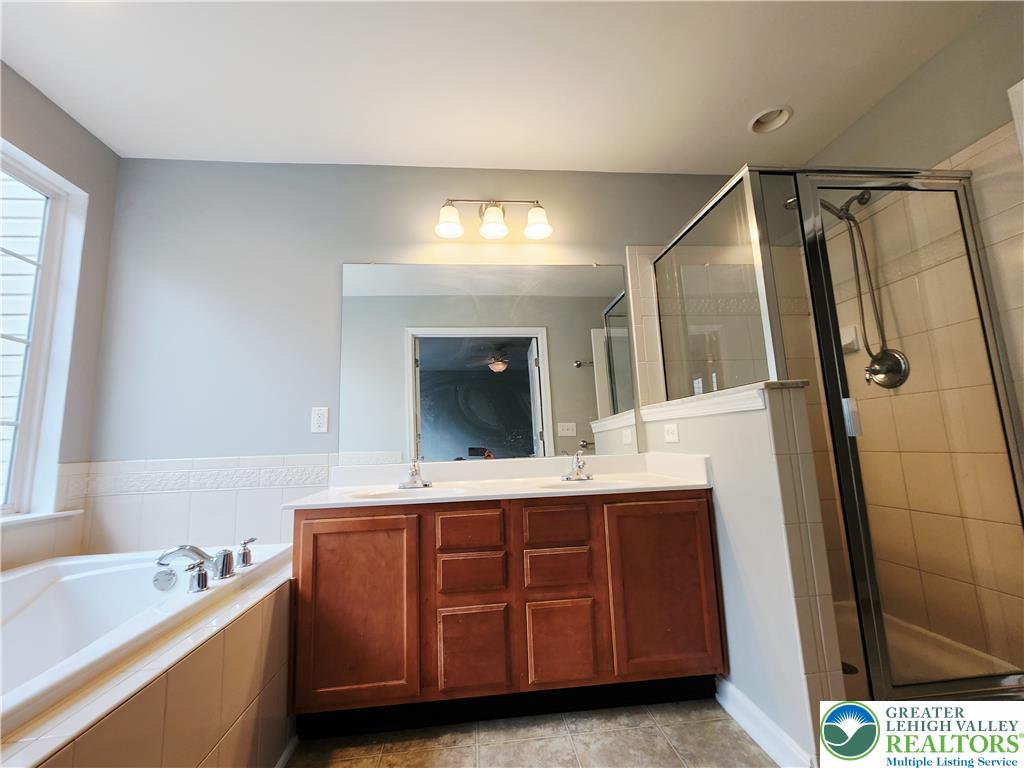 8513 Gateway Road Breinigsville, PA 18031 - Photo 30 of 45 Indulge in a primary bathroom offering a soaking tub and a spacious glass-enclosed shower.