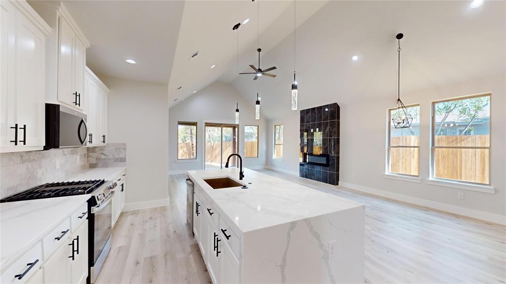 1609 Sharon Street Arlington, TX 76010 - Photo 9 of 29 a kitchen with granite countertop a stove a sink a center island and windows