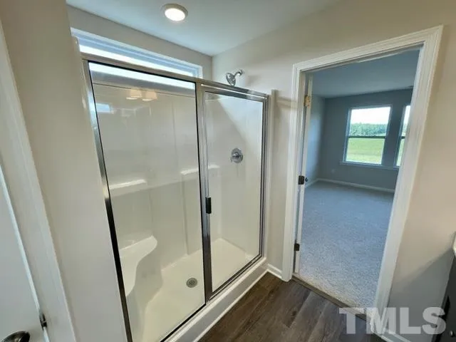 a bathroom with a glass door shower and a mirror