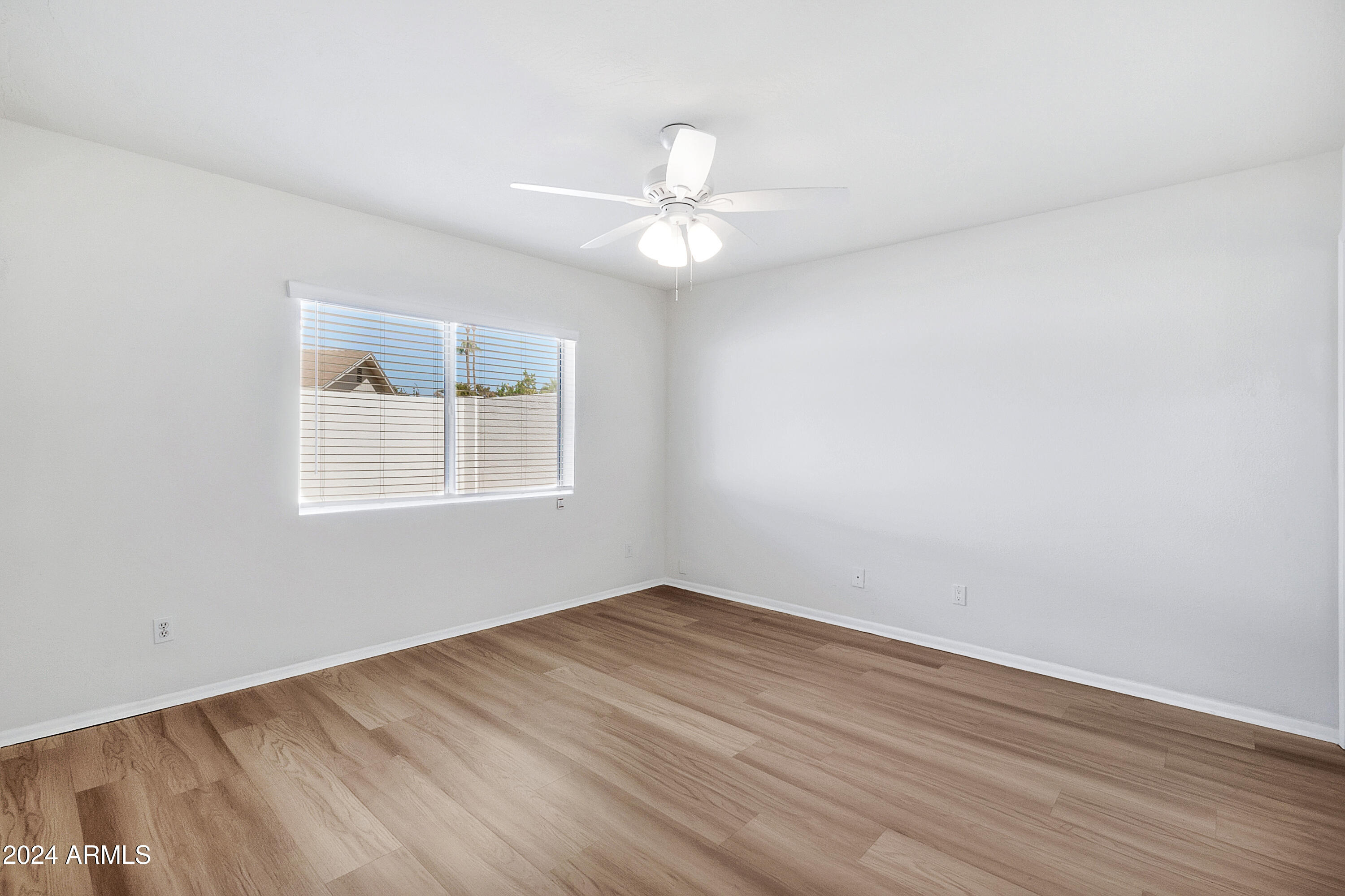 5234 East Blanche Drive Scottsdale, AZ 85254 - Photo 11 of 20 an empty room with wooden floor ceiling fan and window