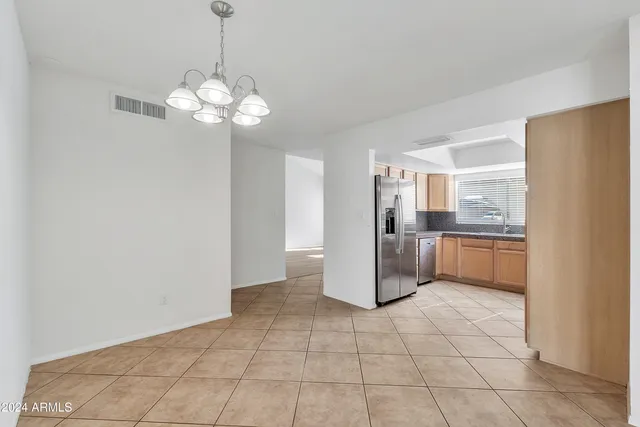 a kitchen with stainless steel appliances granite countertop a refrigerator a sink dishwasher a stove and white cabinets