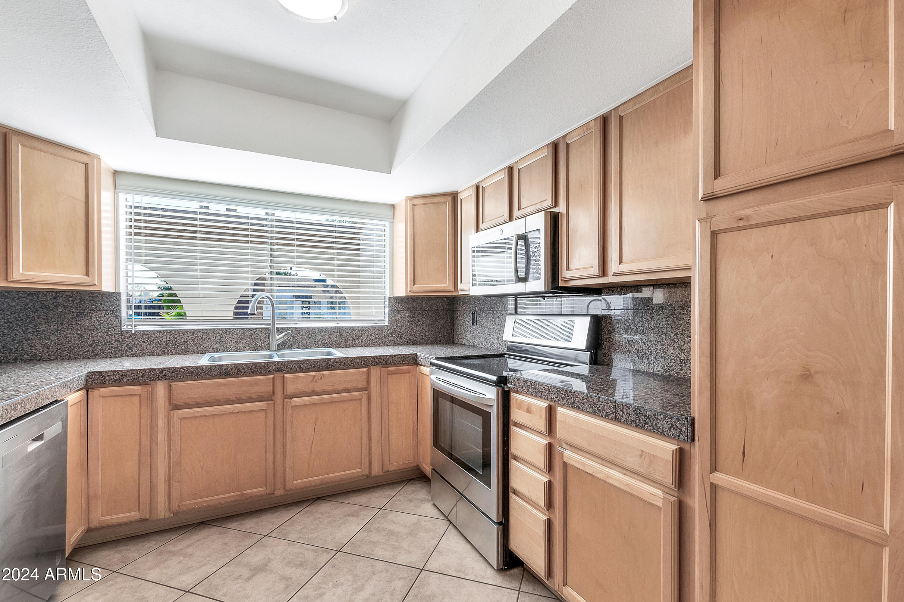 5234 East Blanche Drive Scottsdale, AZ 85254 - Photo 7 of 20 a kitchen with stainless steel appliances granite countertop white cabinets sink and window