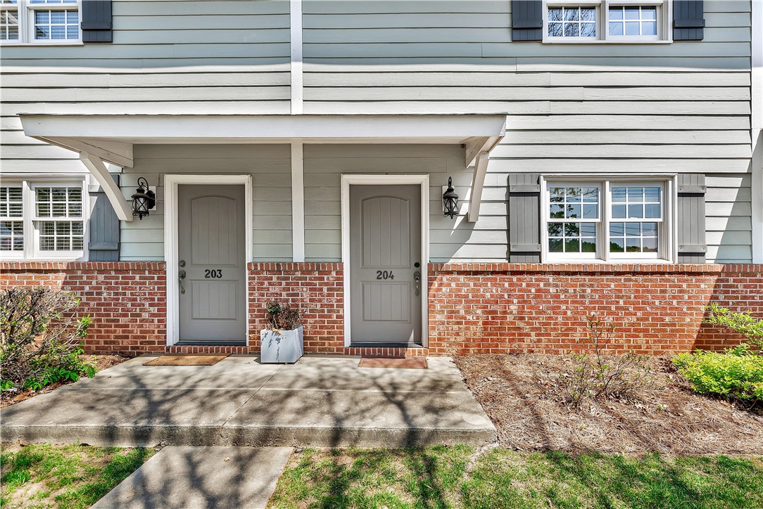 209 Calhoun Street Clemson, SC 29631 - Photo 3 of 25 A welcoming front porch features classic brick accents and detailed siding.