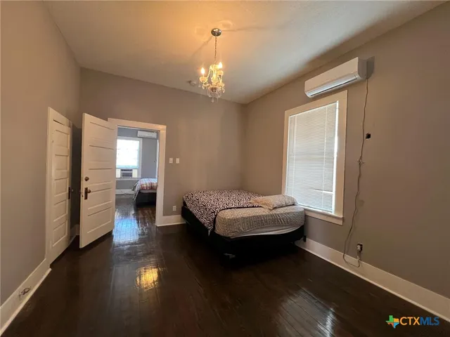 a bedroom with a bed and a chandelier