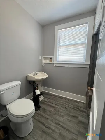 a bathroom with a toilet a sink and a window