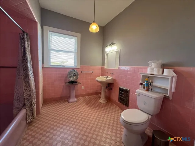 a bathroom with a sink toilet vanity and window