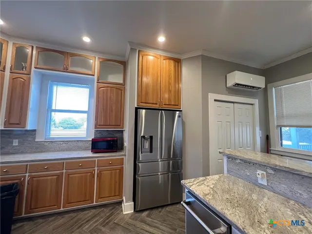 a kitchen with kitchen island granite countertop a refrigerator stove and sink