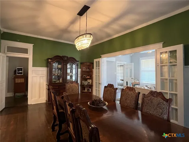 a view of a dining room with furniture wooden floor and chandelier