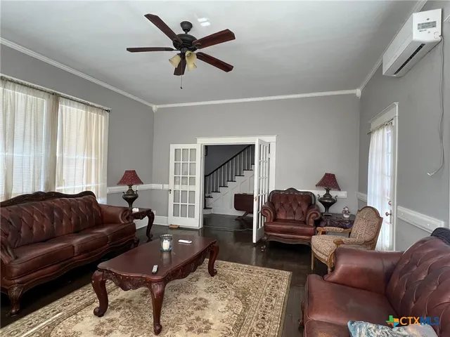 a living room with furniture ceiling fan and a window