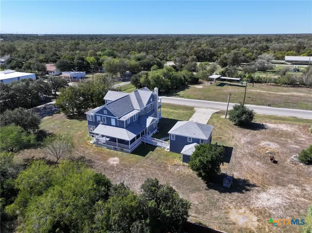 an aerial view of a house with a yard basket ball court and outdoor seating