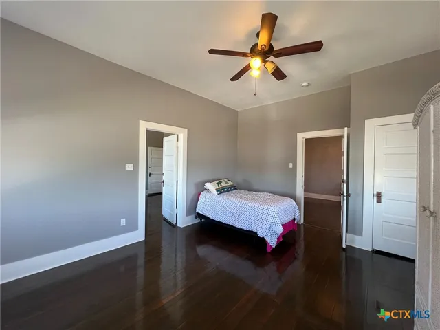 a bedroom with a bed and a ceiling fan