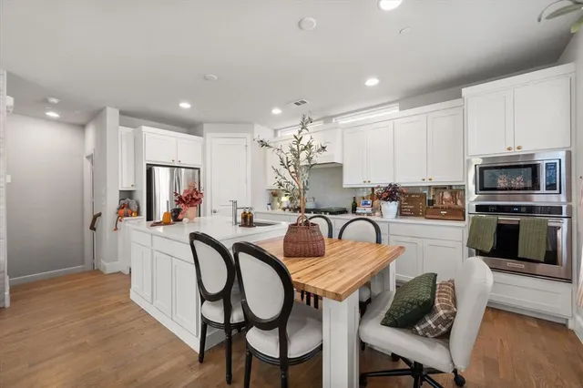 a kitchen with granite countertop a table chairs microwave and cabinets
