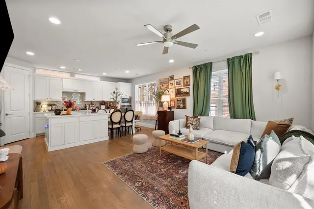 a living room with furniture kitchen view and a large window