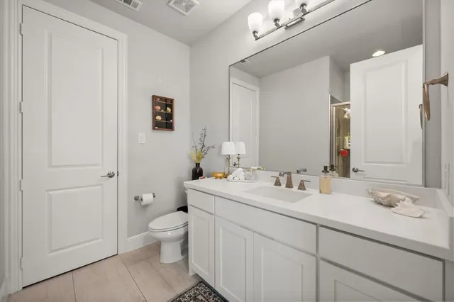 a bathroom with a double vanity sink toilet and a mirror