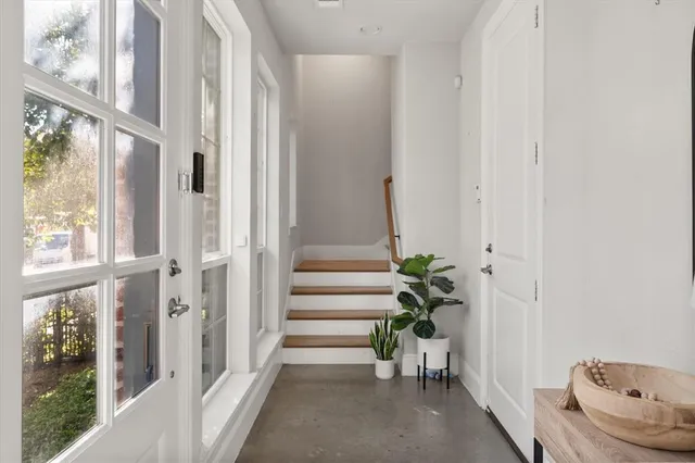 a view of a hallway with wooden floor and windows
