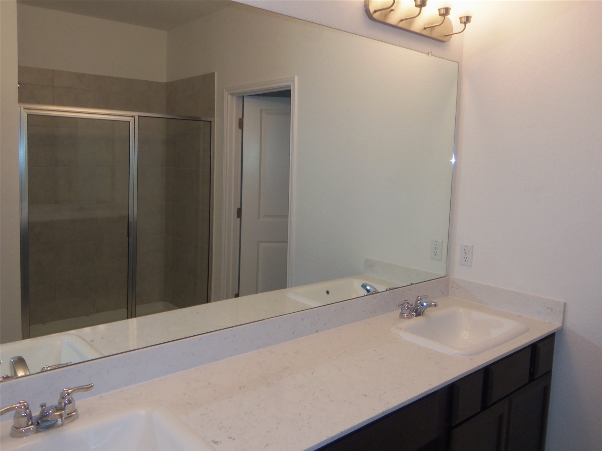 303 Cold Springs Loop Bastrop, TX 78602 - Photo 8 of 13 Dual vanities and a spacious shower elevate daily routines in this well-appointed bathroom.