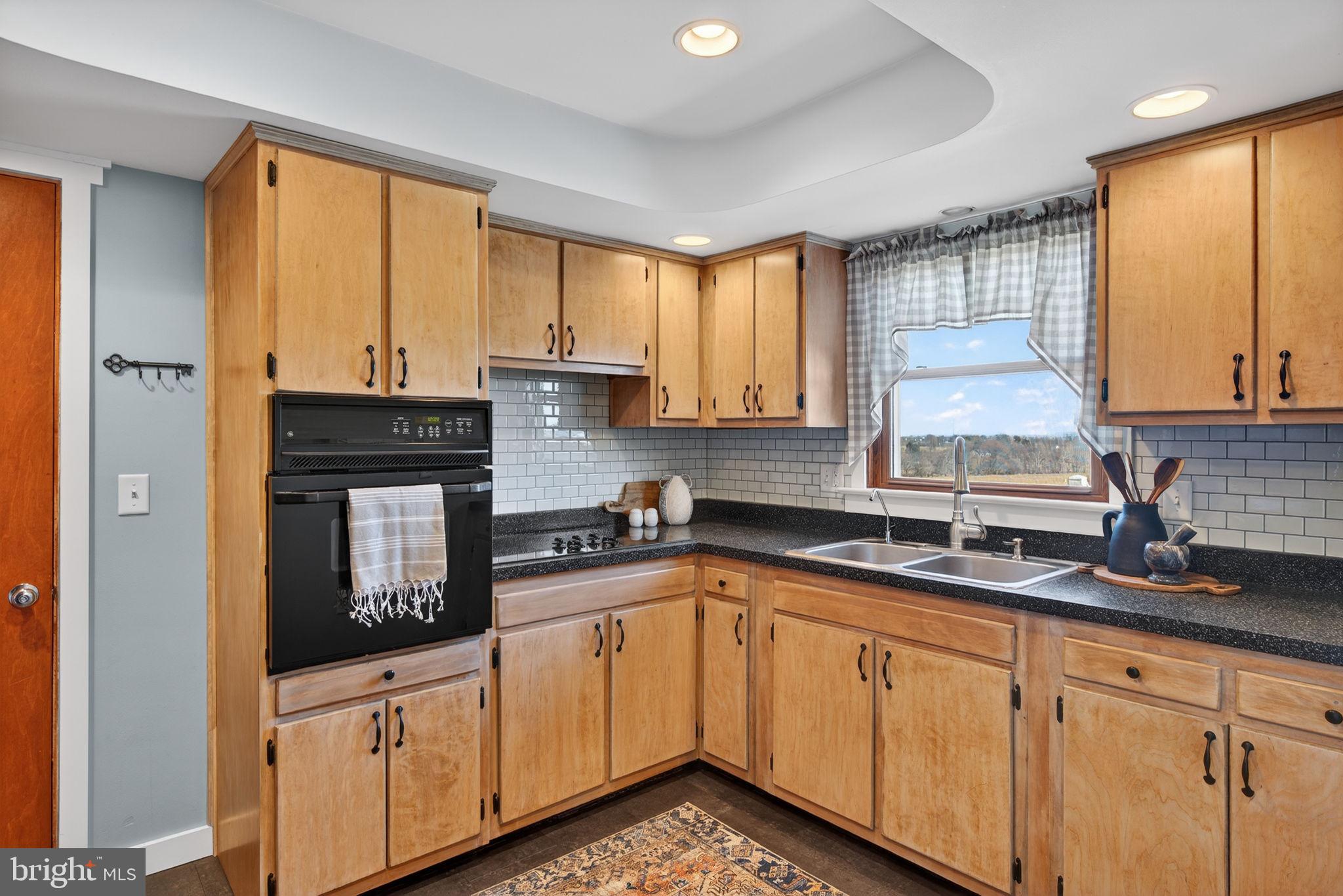 2103 South View Road Lancaster, PA 17602 - Photo 10 of 35 a kitchen with granite countertop a sink stainless steel appliances white cabinets and a window