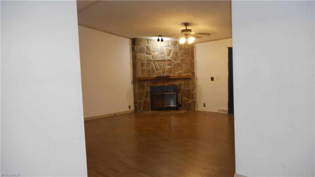 2621 Baltimore Road East Bend, NC 27018 - Photo 15 of 37 Living Room With Ceiling Fan, Laminate Flooring & Stone Fireplace