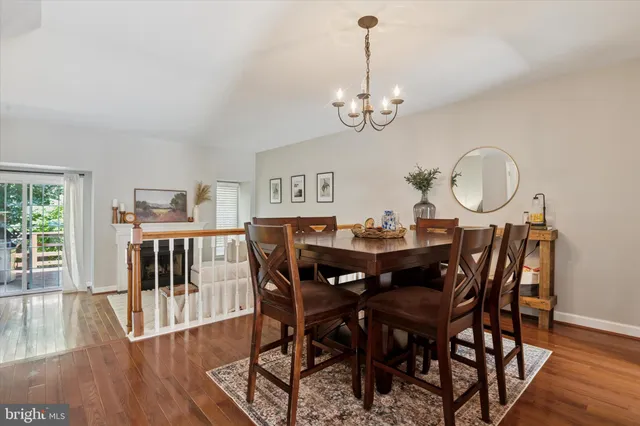 a view of a dining room with furniture a chandelier and wooden floor