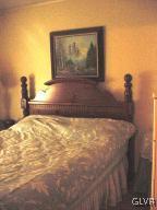 221 D Short Ridge Road, Unit 221 Albrightsville, PA 18210 - Photo 4 of 6 a bed sitting in a bathroom next to a blue wall