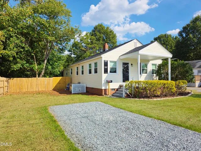 a view of a house with backyard and trees