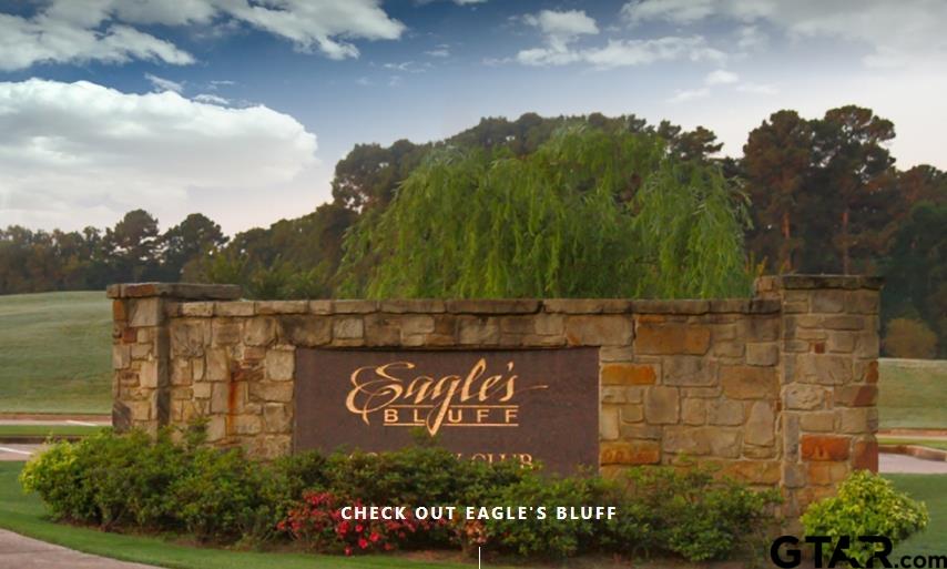 a view of sign board with lake and trees in the background