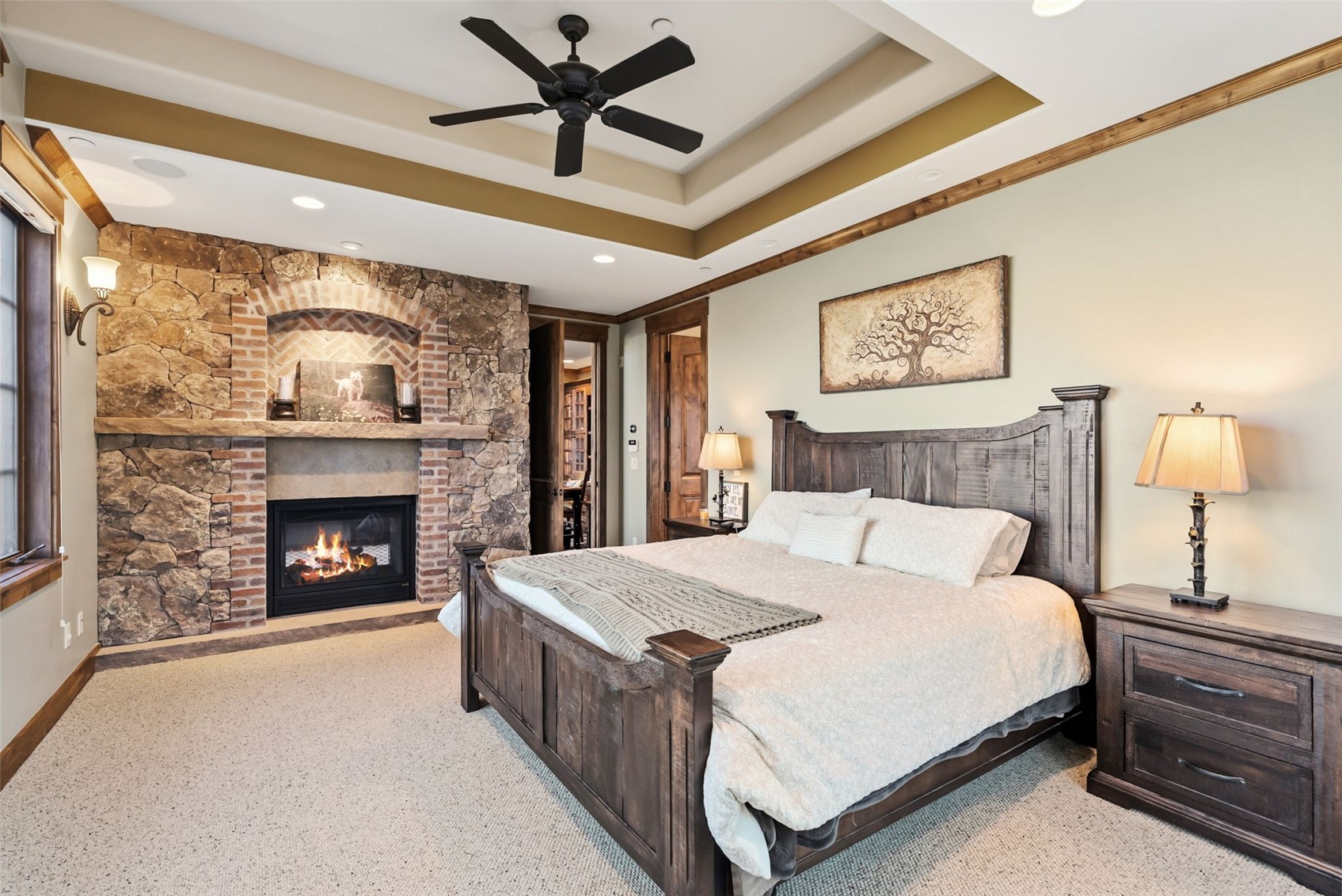 2140 Hunter's Knob Road Silverthorne, CO 80498 - Photo 20 of 46 Bedroom with a large fireplace, ceiling fan, recessed lighting, and a tray ceiling