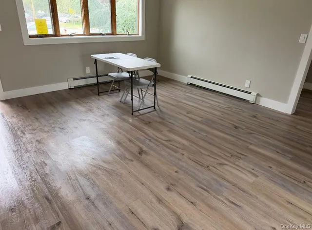 an empty room with wooden floor and a window