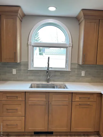 a kitchen with granite countertop white cabinets window and sink