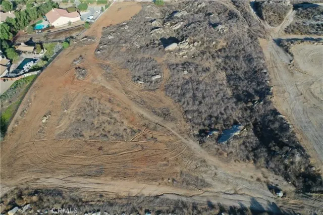 a view of a dry yard with trees