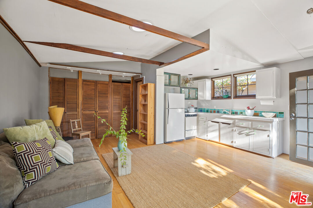 761 Palms Boulevard Venice, CA 90291 - Photo 24 of 26 a kitchen with stainless steel appliances kitchen island granite countertop a refrigerator oven a sink a dining table and chairs with wooden floor