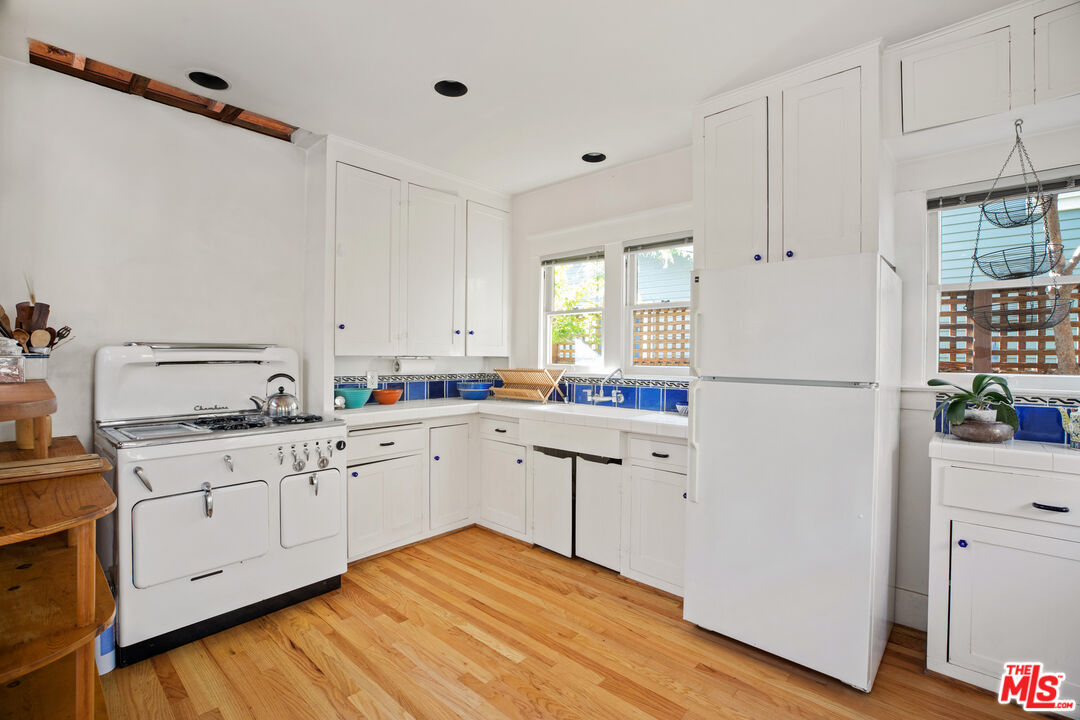 761 Palms Boulevard Venice, CA 90291 - Photo 8 of 26 a kitchen with white cabinets and white appliances