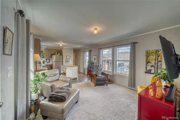 a living room with furniture a window and a flat screen tv