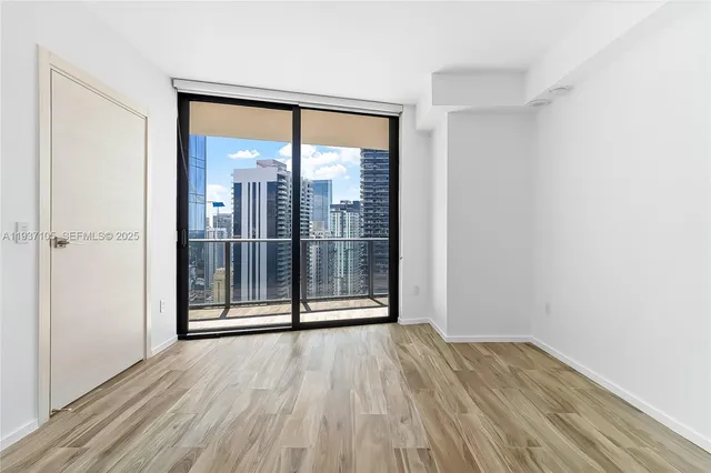 an empty room with wooden floor and door