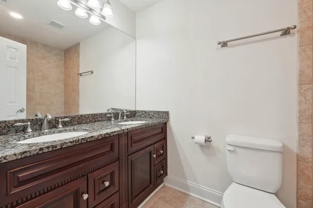 a bathroom with a granite countertop sink toilet and shower