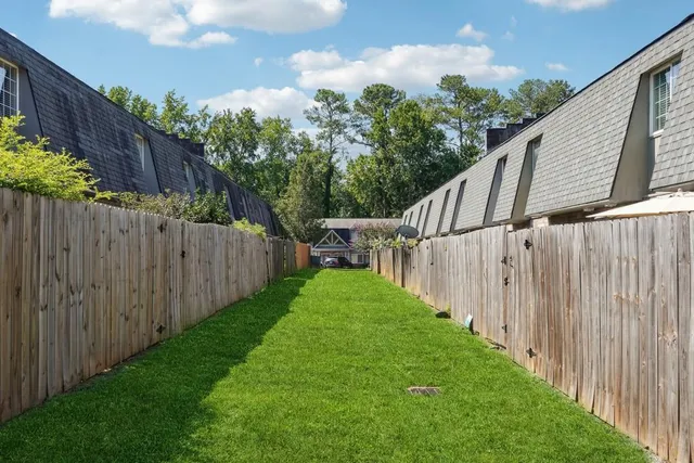 a view of a yard with wooden fence